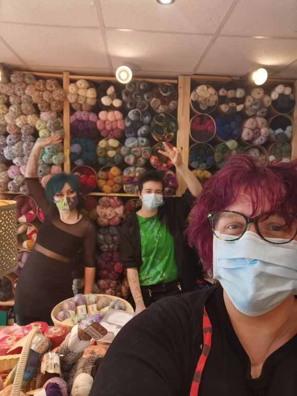 A selfie Katie, Casper and Eleanor in front of a wall of wool. 