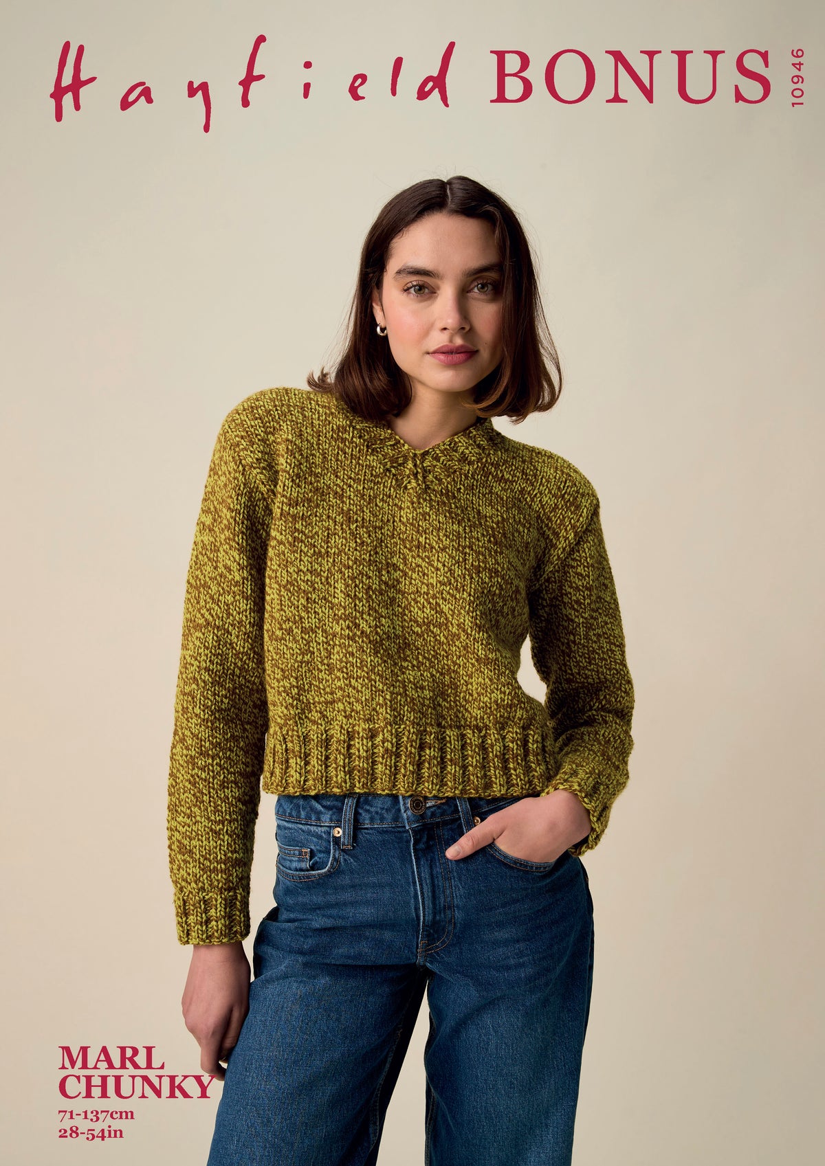 A woman modeling a chunky knit sweater in a mustard yellow-green color, paired with blue jeans, against a solid beige background. The image includes text overlays reading 'Hayfield BONUS' at the top and 'MARL CHUNKY' at the bottom left.